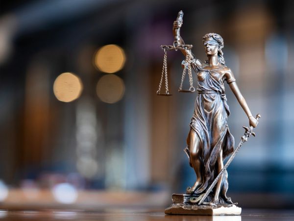 Statue of Lady Justice holding scales and a sword, symbolizing fairness and law.