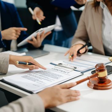 People discussing a contract with legal symbols on the table.