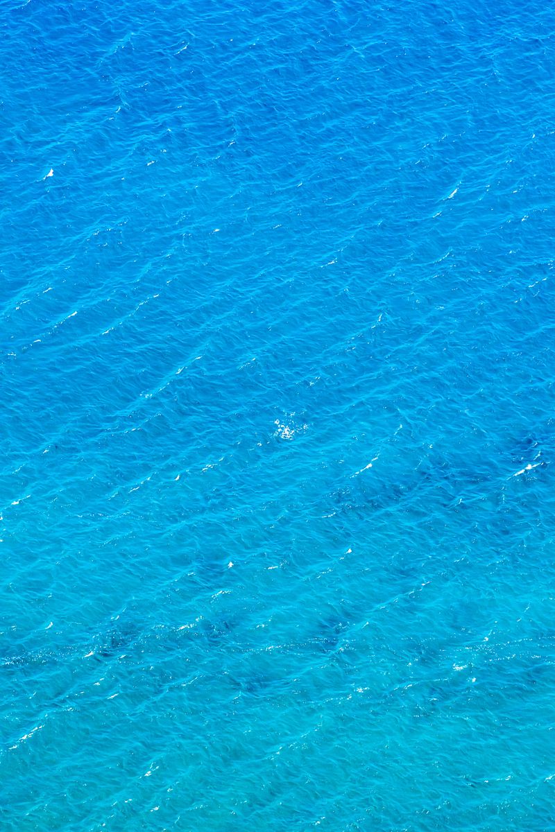 The image is of a body of water with a blue color. The water appears to be calm and still, with no visible waves or ripples