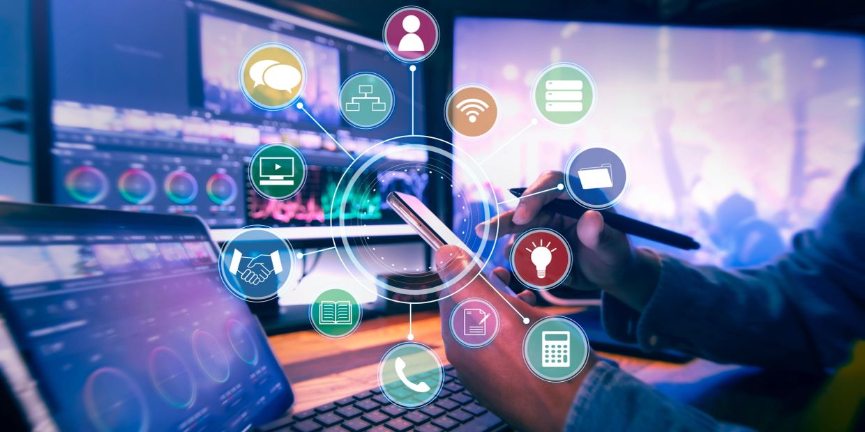 Person using smartphone and laptop with tech icons overlay.