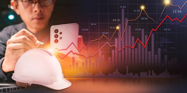 Man analyzing data with smartphone and construction helmet in foreground.