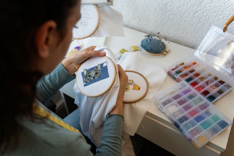 Magic of embroidery through the graceful hands of a young woman, whose skillful stitches bring patterns to life on fabric. Her passion for needlework shines in this captivating portrayal.