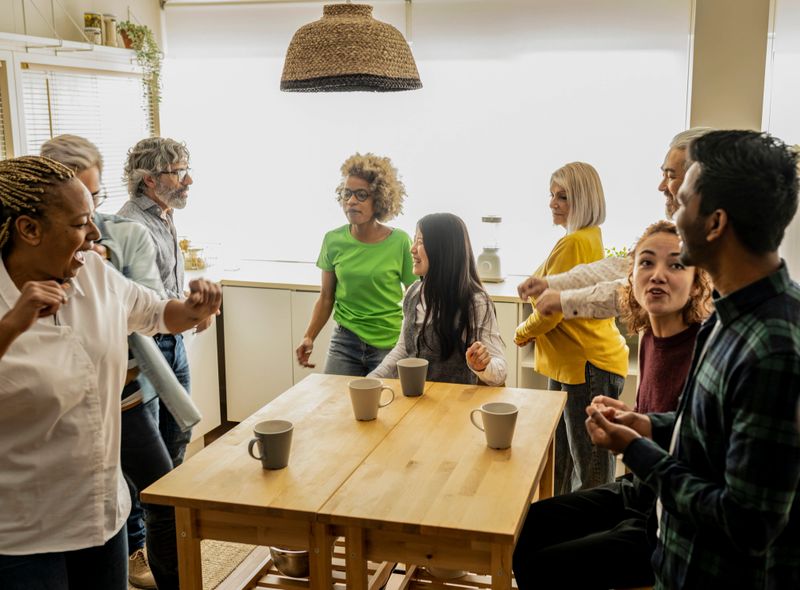 A diverse team actively participates in a team-building exercise, enjoying a moment of connection and fun in their naturally lit office.