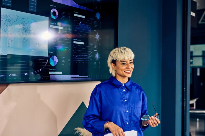 Professional presenting data on digital display in corporate office