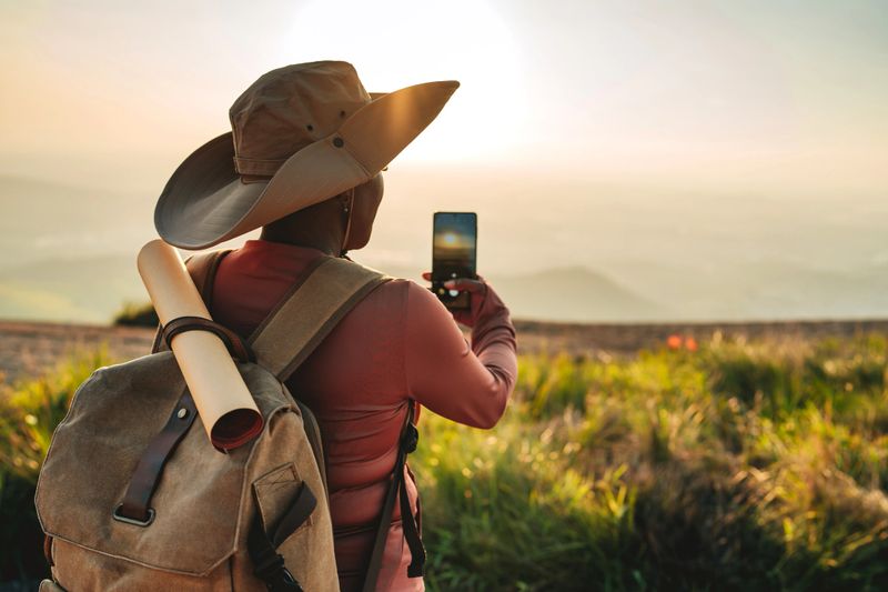 Tourist taking photo of the sunset on the mountain