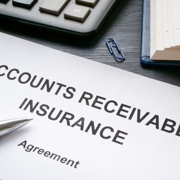 Close-up of an accounts receivable insurance agreement document with a pen and calculator.