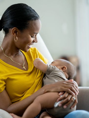 Mother breastfeeding her baby with a smile.