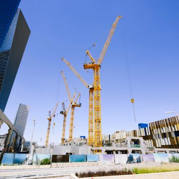 Construction site with cranes and blueprints.