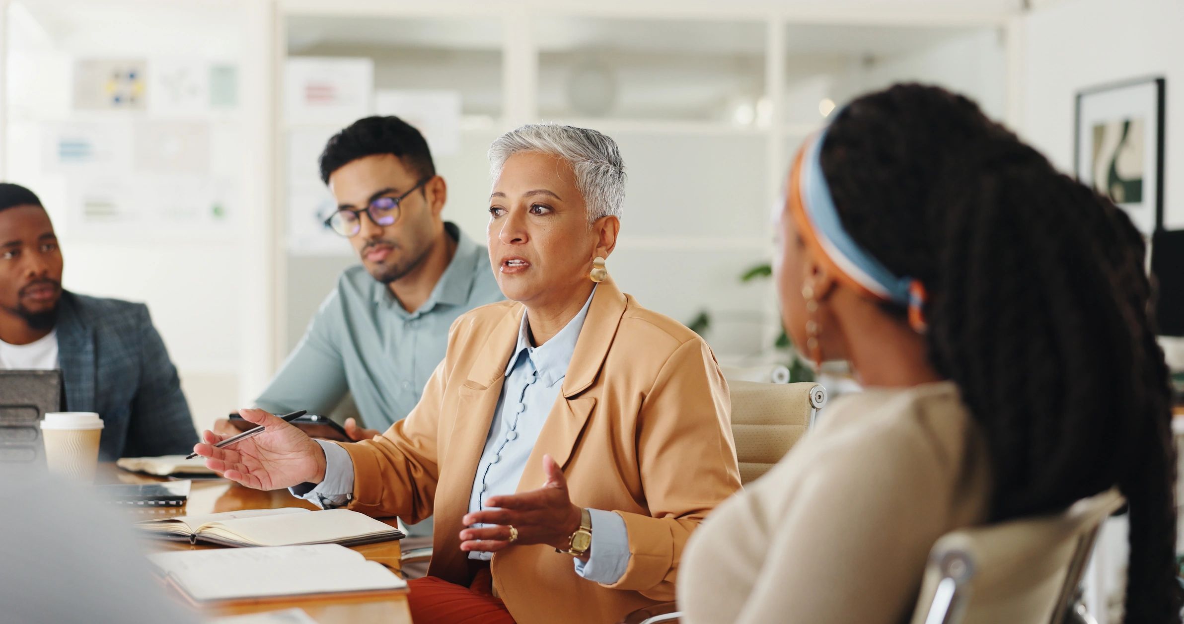 Businesswoman leading a meeting with attentive colleagues.