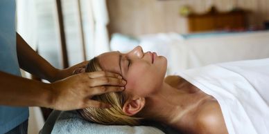 Woman receiving a relaxing head massage at a spa.