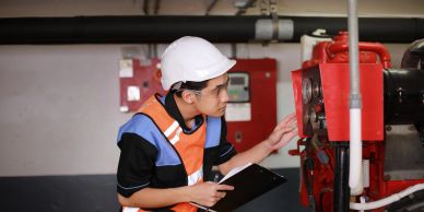 Technician inspecting a machine in a factory.