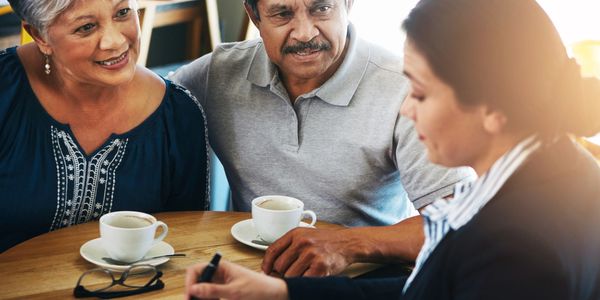 Senior couple consulting with a professional over coffee.