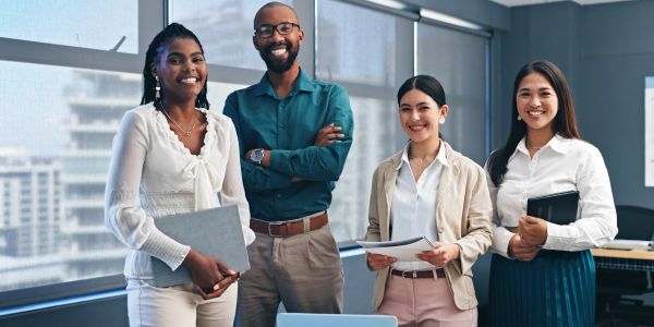 A diverse group of colleagues smiling in an office.