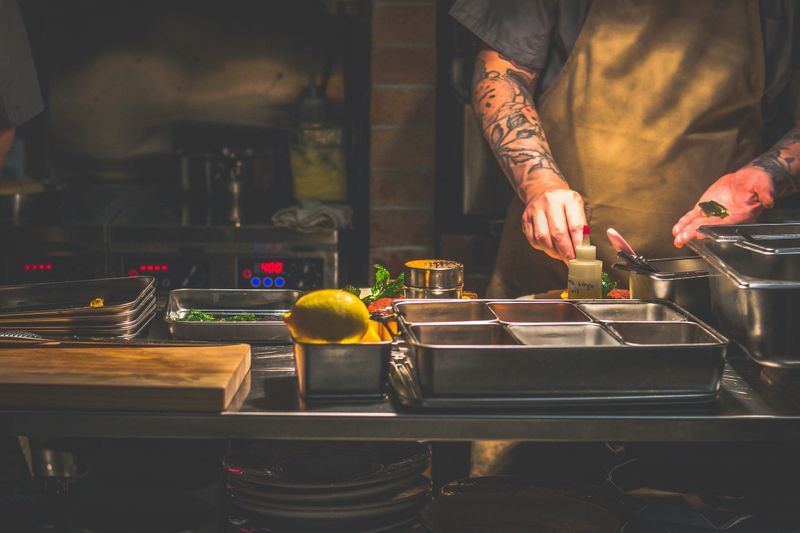 Chef with tattoos workinng in an open fire open kitchen in Singapore