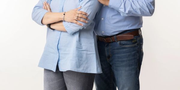 Two people standing side by side with arms crossed.