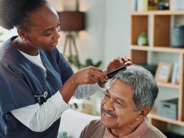 A caregiver combing client’s hair. 