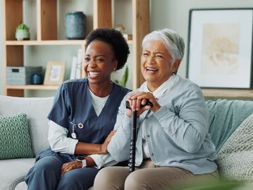 A caregiver and client enjoying television with each other. 
