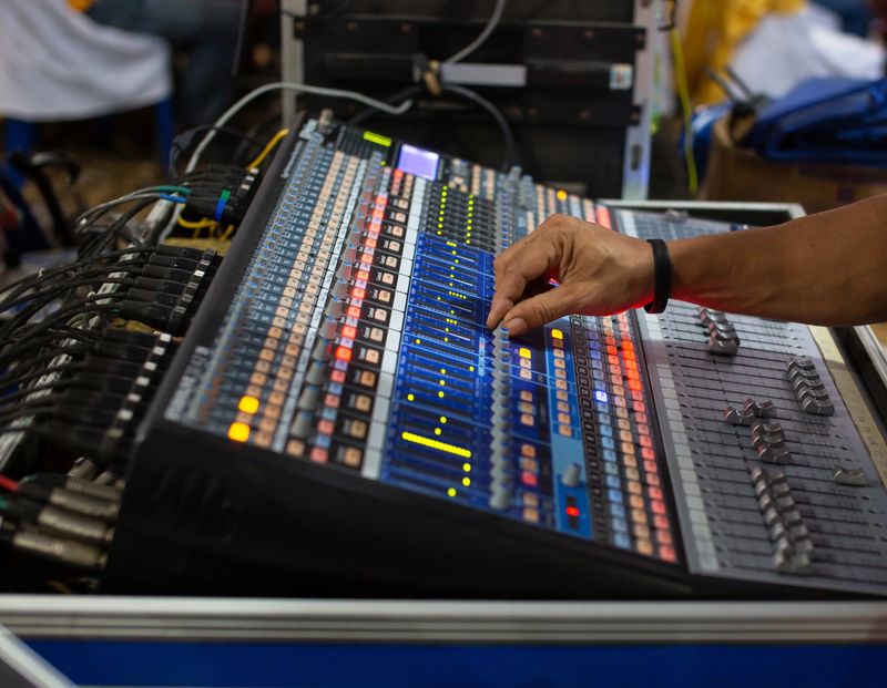 Hands are pressing the buttons to force the sound control panel adjustments.