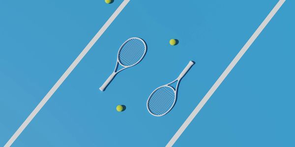 Two tennis rackets and balls on a blue tennis court.