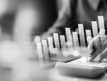 Person using calculator with financial growth charts overlay.