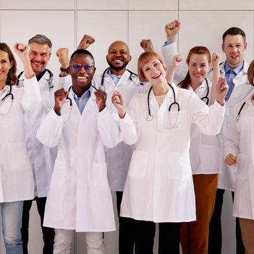 A diverse group of doctors cheering with raised fists, showing unity and enthusiasm.
