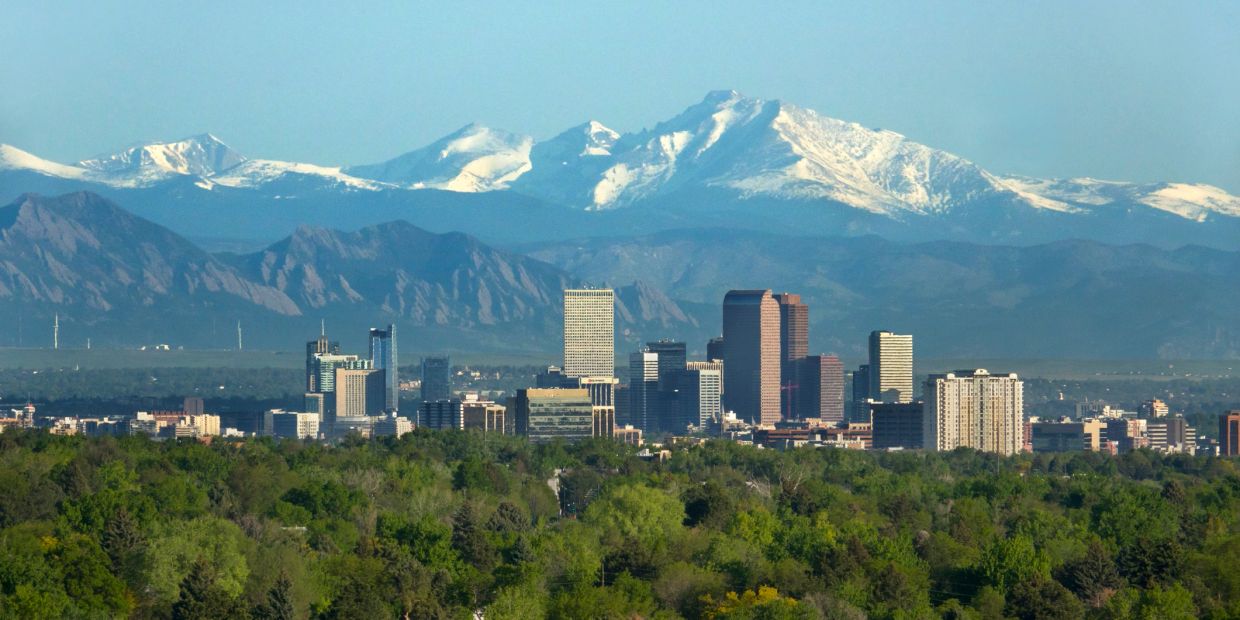City skyline with snowy mountains in the background.