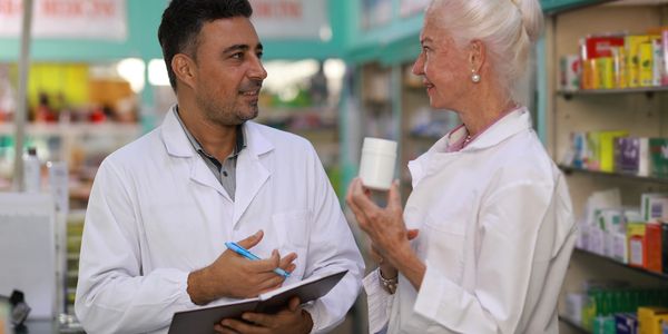 Two pharmacists discussing medication in a pharmacy.