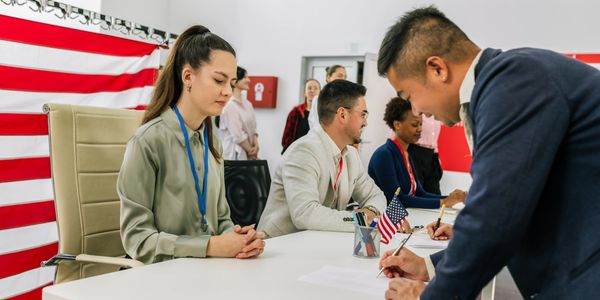 People voting at a polling station with an American flag.