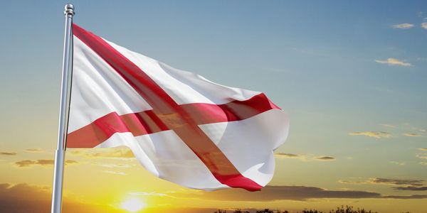 Flag of Alabama waving at sunset.