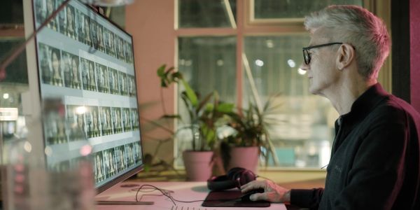 Un homme regarde des photos sur un écran d'ordinateur.