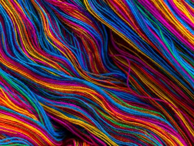Multicolored yarn threads intertwined in a vibrant pattern.