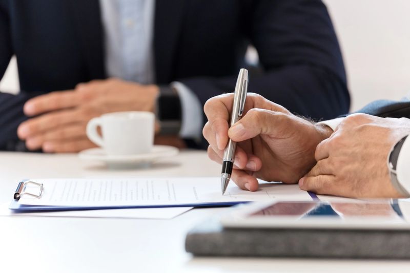Businessman signing a contract. Close up of hands, unrecognizable person.