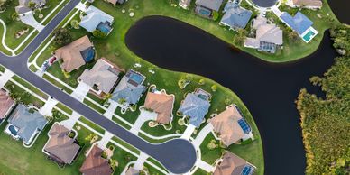 Aerial view of a suburban neighborhood with houses around a curved water body.
