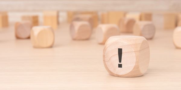 An exclamation mark on a dice set among other dice that are blurry in the background