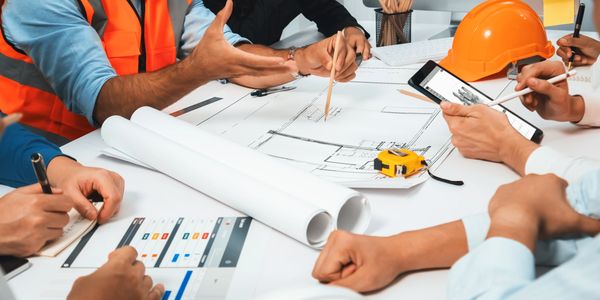 Team of people around a table reviewing project documents