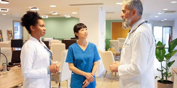 Three medical professionals having a discussion in a modern office.
