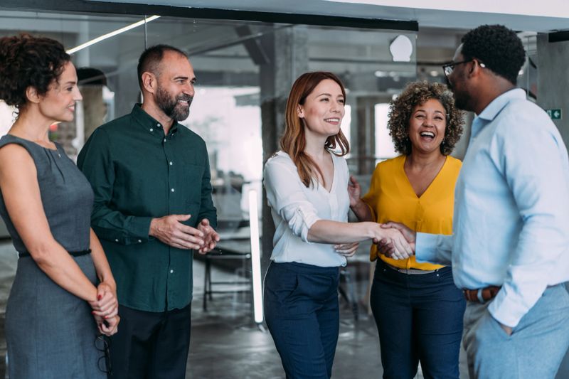 Business people shaking hands in the office. Business persons handshaking during a meeting in modern office.