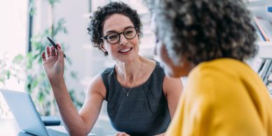 Two women are engaged in a discussion at work.