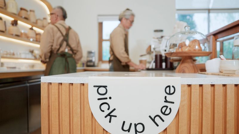 Arrange food pickup at the bar counter in a cafe.