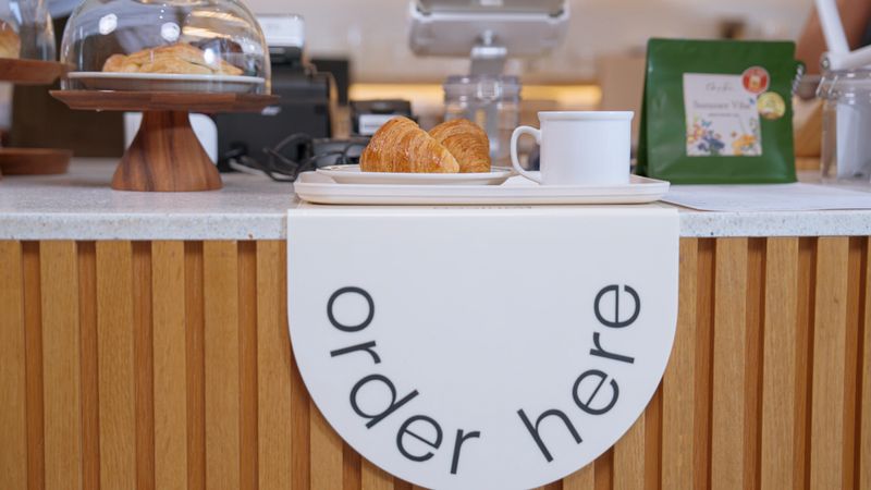 Arrange food pickup at the bar counter in a cafe.