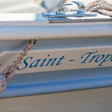 Close-up of a boat named Saint-Tropez showing rope and metal fittings.