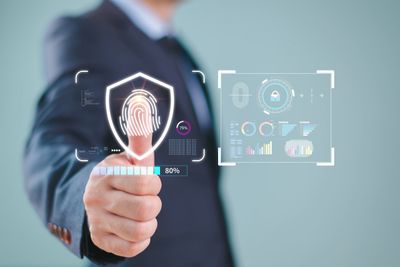 Businessman using fingerprint security technology with digital interface.