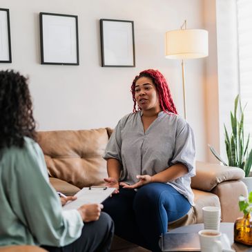 Two women engaged in a counseling session in a cozy living room.