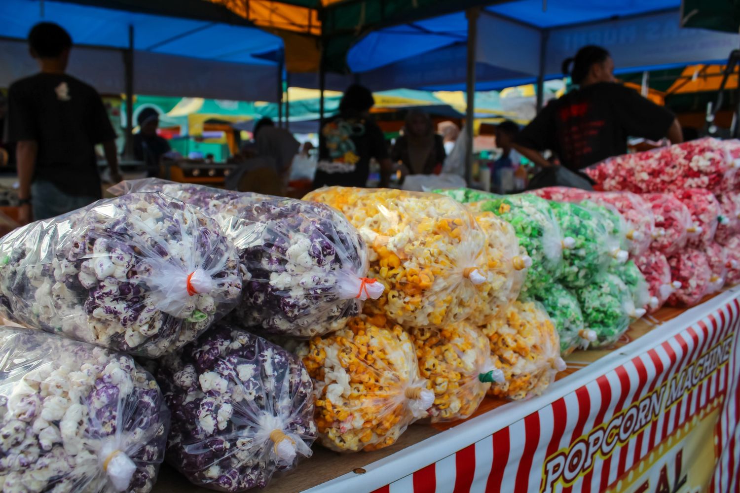 Colorful bags of popcorn displayed at an outdoor market stall.