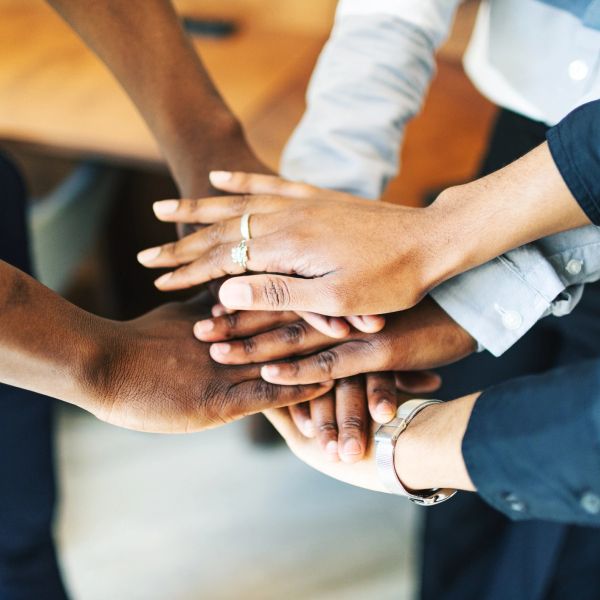 Hands stacked together symbolizing teamwork.
