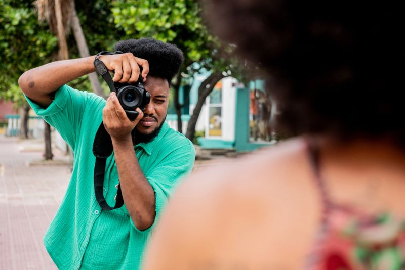 Young photographer man taking photos of woman outdoors