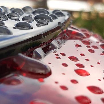 Water beads itting on the roof of a car as a result of the car having a ceramic coating applied