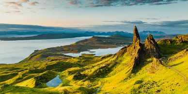 Landscape with rocky peaks and green hills.