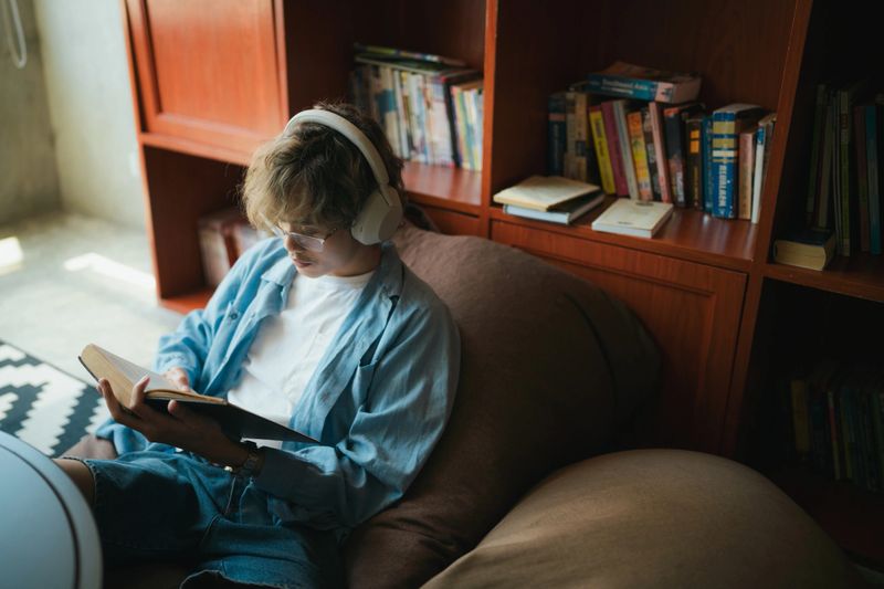 Asian Guest Immersed in Book, Finding Peace in Common Area Ambience.