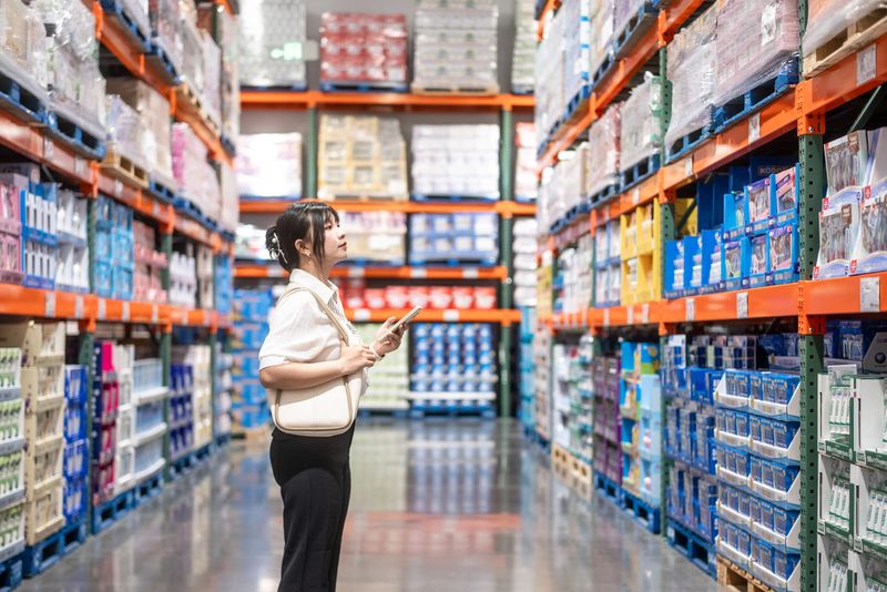 asian female holding smart phone in supermarket